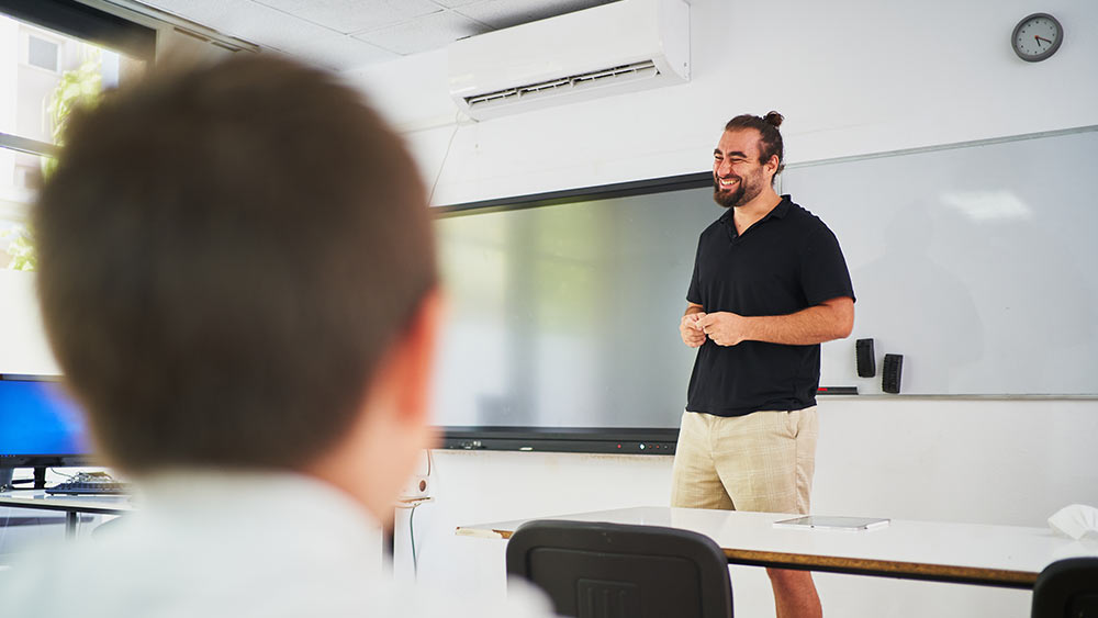 Mini-split AC instalado en un salón de clases.  Un profesor da una conferencia en un aula acogedora.